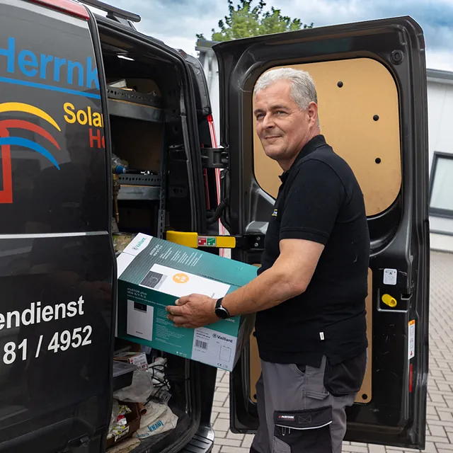 Arbeiter steht am Auto